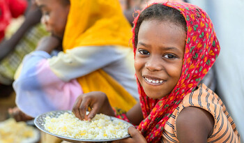 Ein Mädchen aus dem Sudan mit einem Reisteller Ein Mädchen aus dem Sudan mit einem Reisteller
